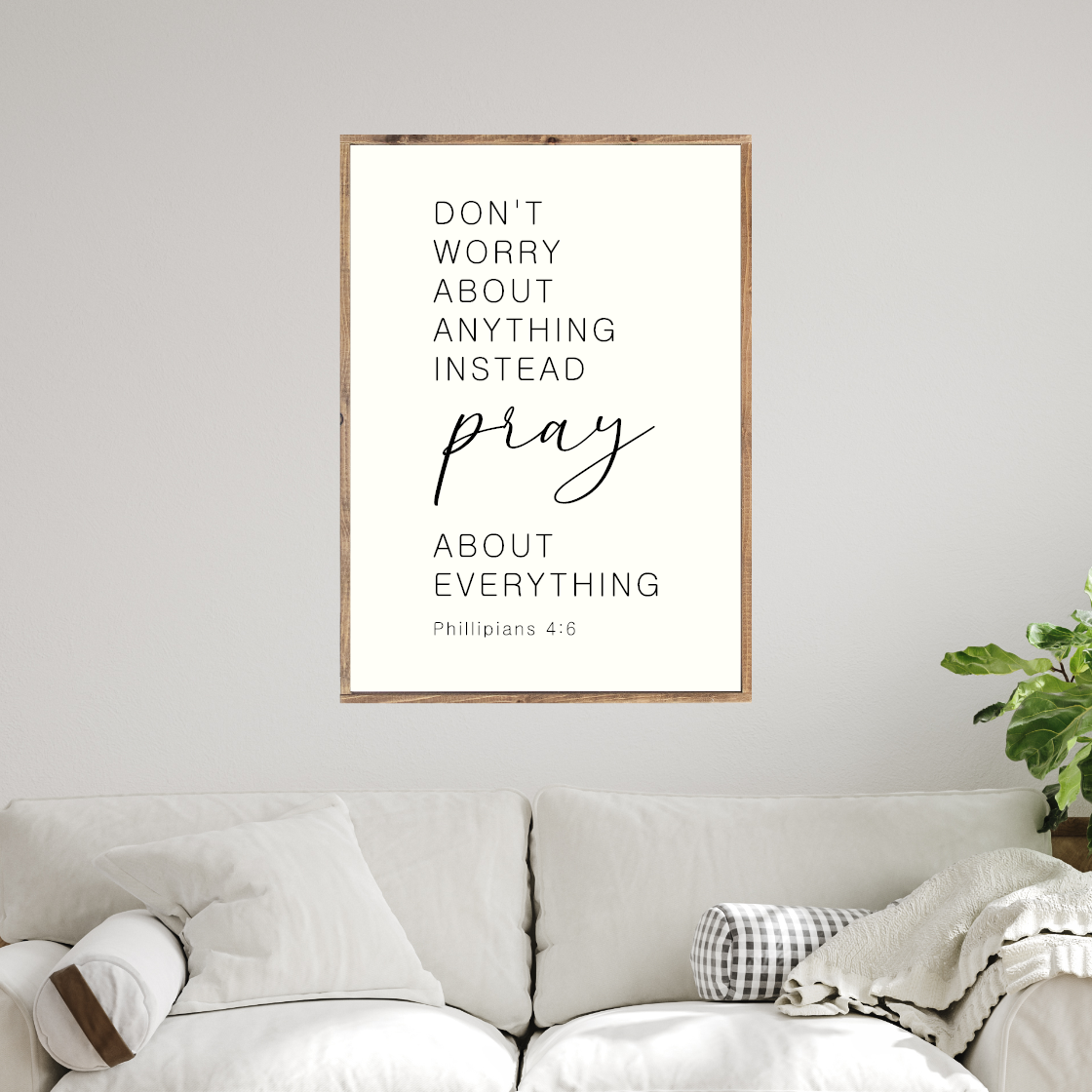 a framed inspirational quote on a wall above a white couch.