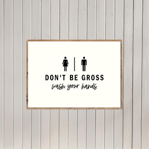 a sign with the text "DON'T BE GOSS" and "WASH YOUR HANDS" written on it, along with two simple pictograms representing a man and a woman.